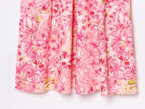 Gros plan détaillé du tissu à imprimé floral rose avec ourlet fini sur une robe d'été