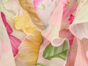 Dettaglio del tessuto in chiffon a fiori con bordi a balze e motivi floreali