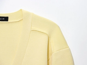 Detail shot of the knit cardigan's collar with a high-quality brand label and fabric texture