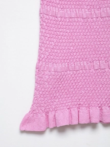 Detailed macro view of pink smocked knit fabric with elegant ruffled hemline design