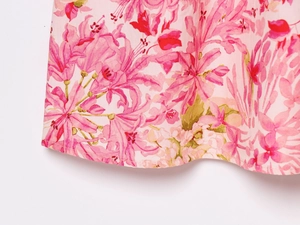 Détail de l'imprimé floral sur tissu rose clair avec couture d'ourlet soignée