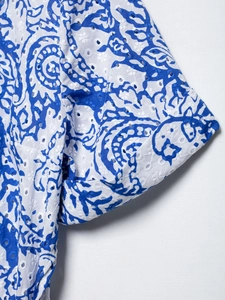 Gros plan détaillé de la broderie anglaise paisley bleue et des coutures sur la robe