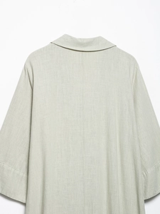 Detail view of the back of a beige linen dress with a classic collar and center seam