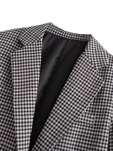 Detailed close-up of classic black and white houndstooth blazer with smooth inner lining