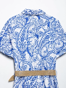 Détail d'une robe d'été à motif paisley bleu avec broderie anglaise et ceinture tressée