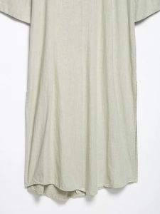 Detail of sage green linen blend fabric showing natural fiber texture and side slit