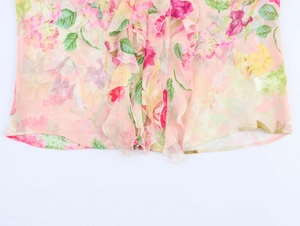 Dettaglio del tessuto in chiffon a fiori rosa con delicate balze e trama semitrasparente