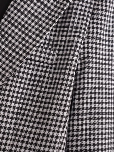 Close-up of premium houndstooth weave texture and precise stitching on the suit lapel