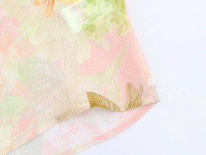 Dettaglio dell'orlo della camicetta in chiffon a fiori con cuciture curate e trama fine