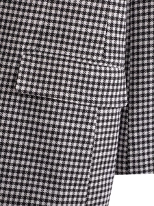 Detailed close-up of classic black and white houndstooth fabric with a flap pocket