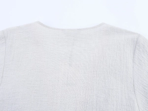 Detailed macro view of the beige cotton-linen fabric texture and round neckline stitching