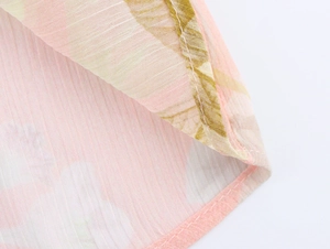 Dettaglio delle cuciture e della stampa floreale sul leggero tessuto in chiffon a strati