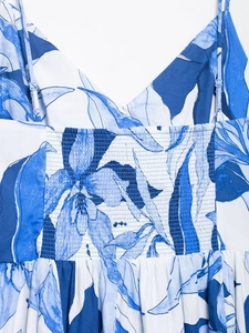 Macro detail of blue floral dress featuring smocked bodice and adjustable thin straps