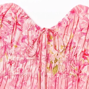 Robe sans manches à fleurs roses avec col en V, taille smokée et cordons réglables