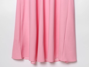 Detail of the pink dress hemline featuring premium stitching and fluid drape fabric