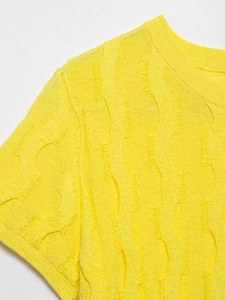 Detailed macro view of yellow knit top featuring unique wave texture and distressed design