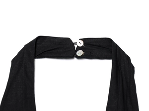 Detail of black halter neckline with dual pearl buttons and textured fabric weave