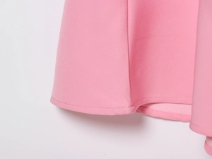 Detail shot of pink dress hem showing high-quality double-stitch sewing and fabric texture