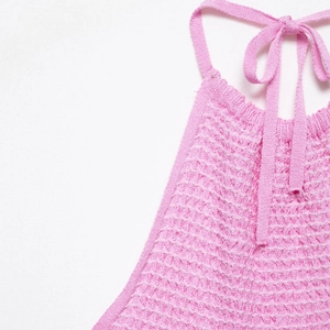 Pink knit halter neck top with textured ribbed fabric and adjustable tie neck design