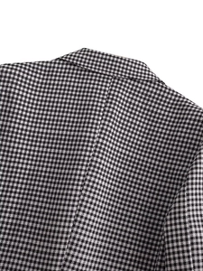 Macro detail of classic black and white houndstooth tweed blazer with neat shoulder stitching
