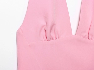 Detail showing elegant pink dress neckline with pleated gathers and deep V-neck design