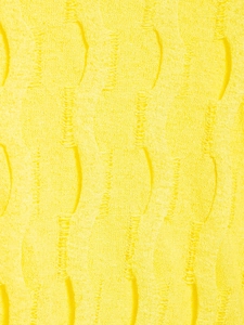 Macro shot of yellow cable-knit fabric with distressed ripple texture and torn design