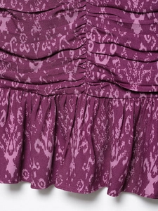 Detailed close-up of purple abstract floral fabric with vertical pleats and ruffled edges