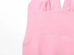Close-up of pink halter dress bust detail with elegant pleated fabric and stitching