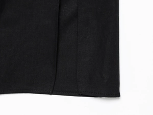 Detail shot of the hemline stitching and high-quality twill fabric on a black midi dress