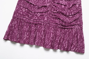 Detail view of purple floral print dress with elegant ruffles and vertical ruching texture