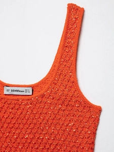 Detailed macro view of vibrant orange knit tank top featuring shiny sequin embellishments