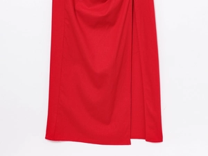 Detail of red midi dress showing textured woven fabric and professional high slit tailoring