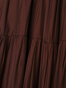 Detailed macro view of tiered brown layered fabric with pleated texture on the dress
