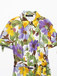 Detailed close-up of floral dress collar with V-neck and branded woven label