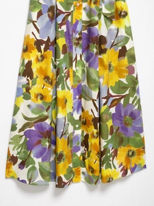 Detail of floral print summer dress featuring a high waist, button-down front, and flowy hem
