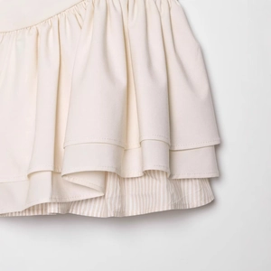 Fashionable ivory tiered halter mini dress with striped inner layer and soft pleated hem