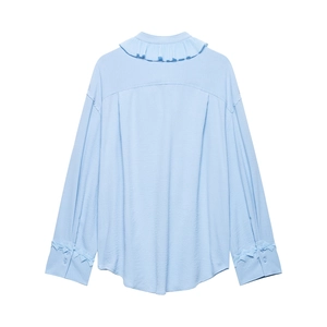 Detail view of light blue ruffled collar and pleated back design on women's casual shirt
