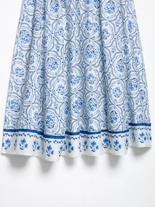 Détail de jupe midi à motifs floraux bleus avec une bordure rayée contrastée