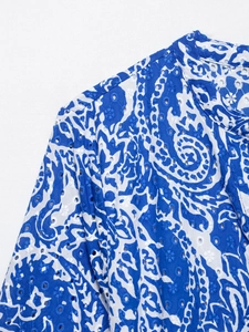 Détail d'imprimé paisley bleu avec broderie anglaise délicate et ajourée