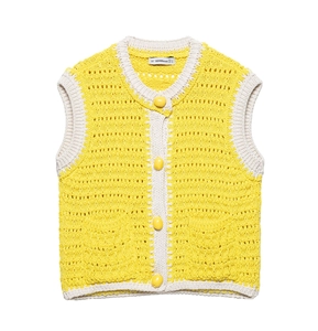 Dettaglio del gilet all'uncinetto giallo e beige con maglia testurizzata e bottoni