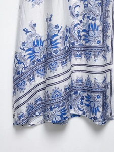 Close-up of blue and white paisley floral print on elegant flowing bohemian skirt fabric