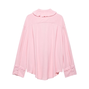 Detail of pink blouse with pleated ruffle collar and decorative zigzag cuffs with buttons