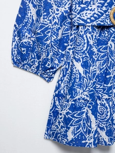 Détail de la robe Broderie Anglaise avec imprimé bleu et boucle de ceinture ronde en paille