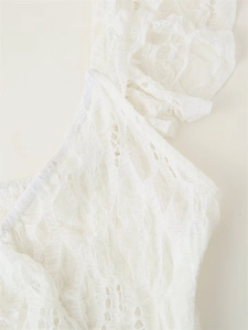 Macro detail of elegant white floral lace fabric with ruffled edge on dress sleeve
