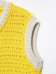 Dettaglio ravvicinato delle cuciture a contrasto giallo e bianco con trama a maglia