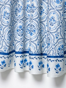 Vue détaillée du tissu en coton et lin blanc avec des motifs floraux bleus