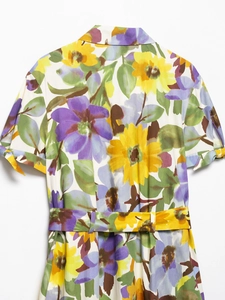 Detail of floral print summer dress featuring v-neck collar and matching waist belt