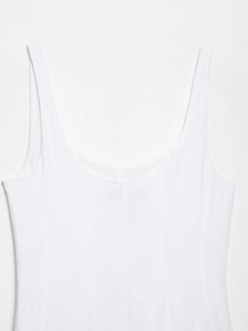 Detailed close-up of a white midi dress with textured fabric and vertical seams