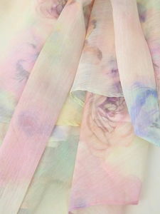Detail of colorful tie-dye floral print on lightweight translucent lace dress fabric