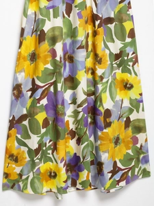 Close-up of floral print summer dress showing yellow and purple flower details on white fabric
